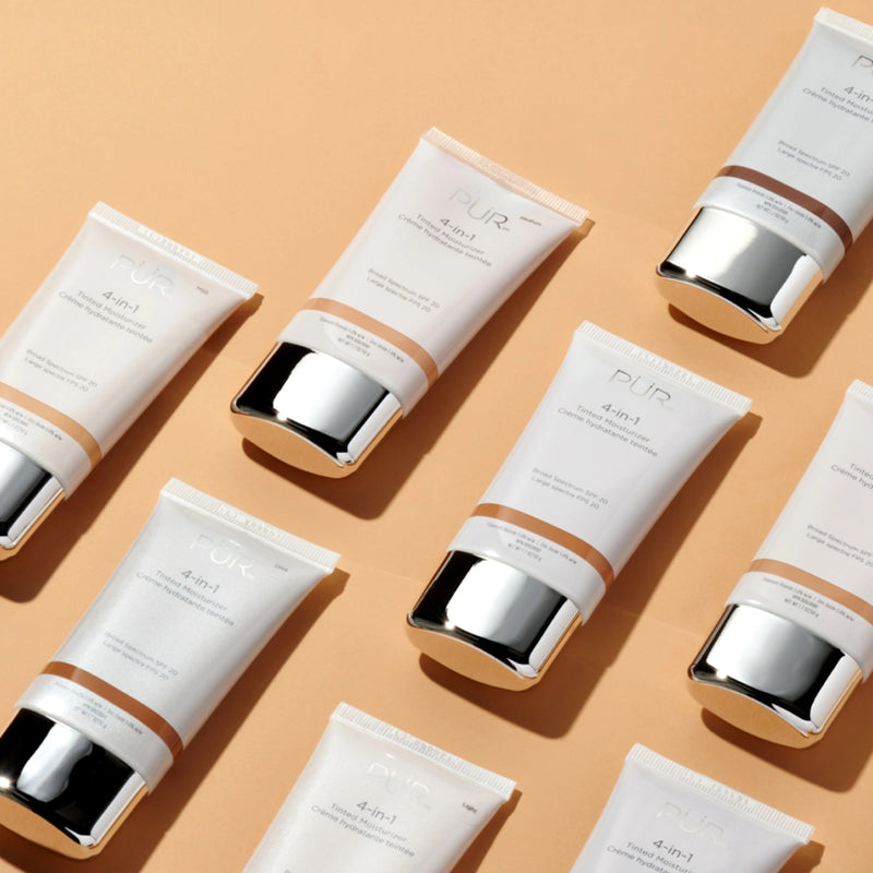 4-in-1 Tinted Moisturizer arranged in a diagonal pattern against a tan background. 