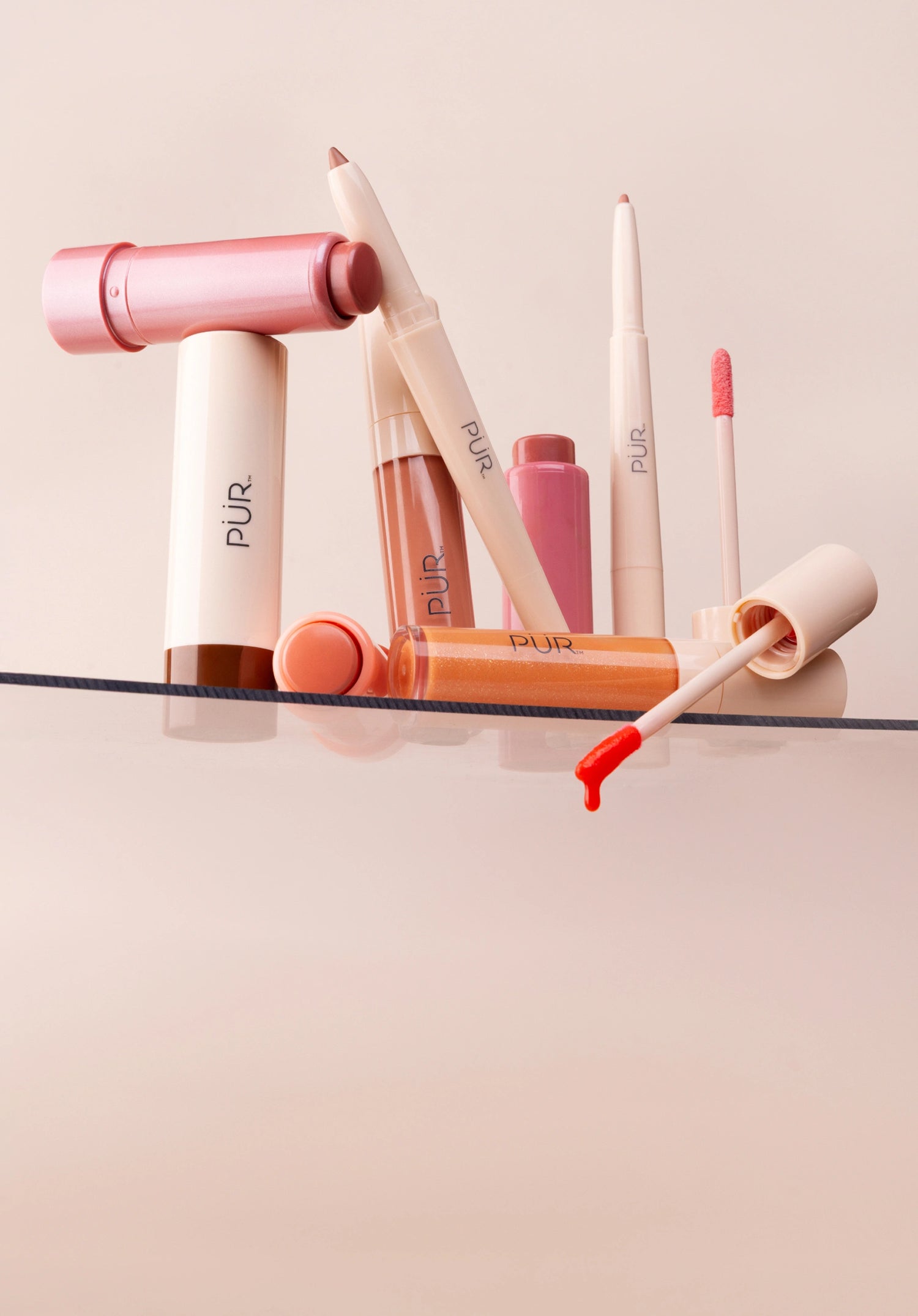 National Lipstick Day: 40% Off Lipstick - Various lip makeup products on glass shelf against pale pink background (mobile)