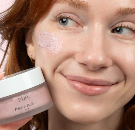 Polish & Radiate Exfoliating Dragon Fruit Mask - woman smiling with silo with swatch on cheek