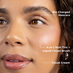 Model wearing full PÜR Skin First Essentials Kit — Bio Charged Mascara, 4-in-1 Skin Tint SPF 50 applied with Liquid Chisel Brush, and Cloud Cream Mini for hydrated, natural glow.
