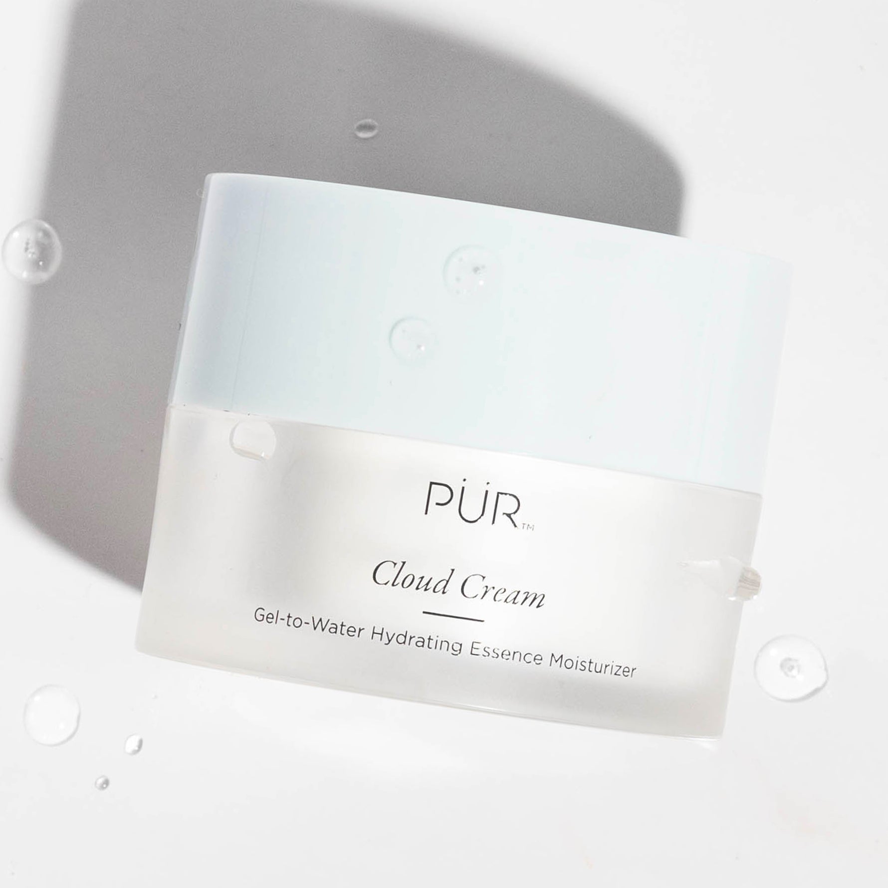 PÜR Cloud Cream jar shown with water droplets to emphasize lightweight hydration and moisture-rich texture.